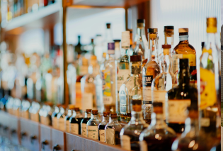 Glass alcoholic bottles lined up against a mirror